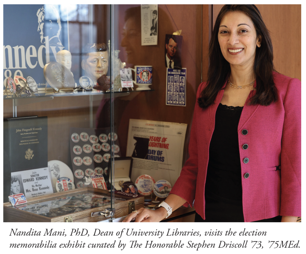 Brown haired woman stands next to display of political memoribilia